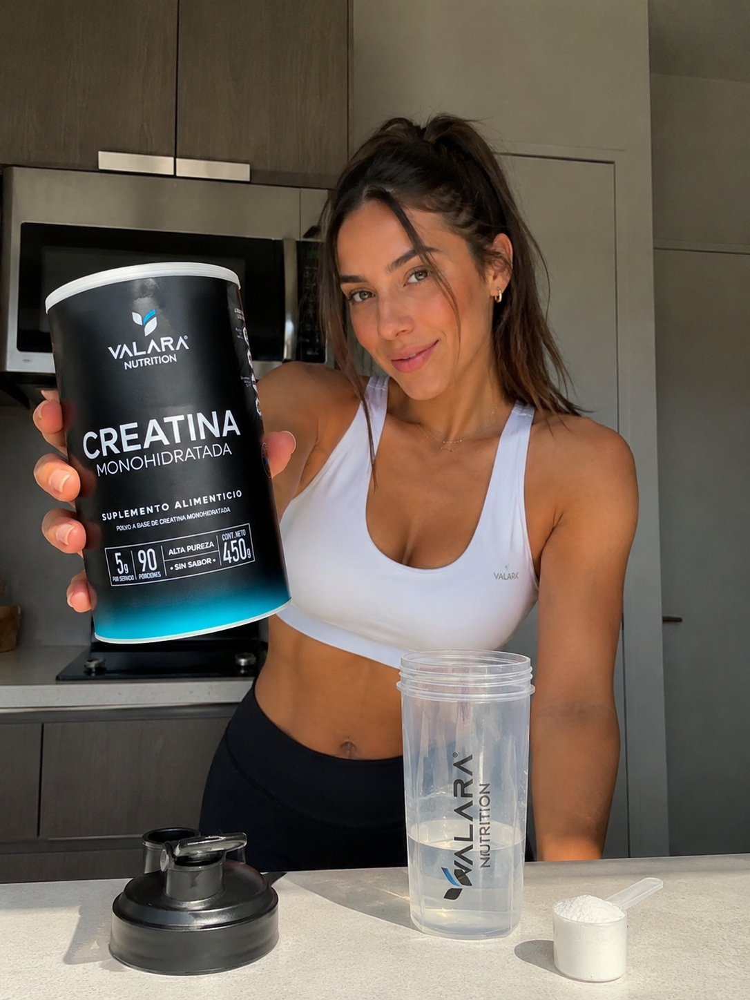 Influencer fitness creada con IA sosteniendo la creatina VALARA