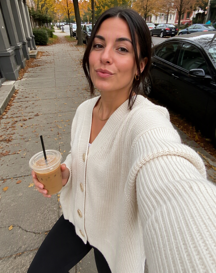 Selfie de una mujer caminando por la calle con un vaso de café en la mano